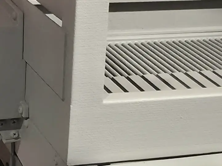 Close-up reference photograph of primed panels, seams, and roller detail on a 3D-printed industrial model.