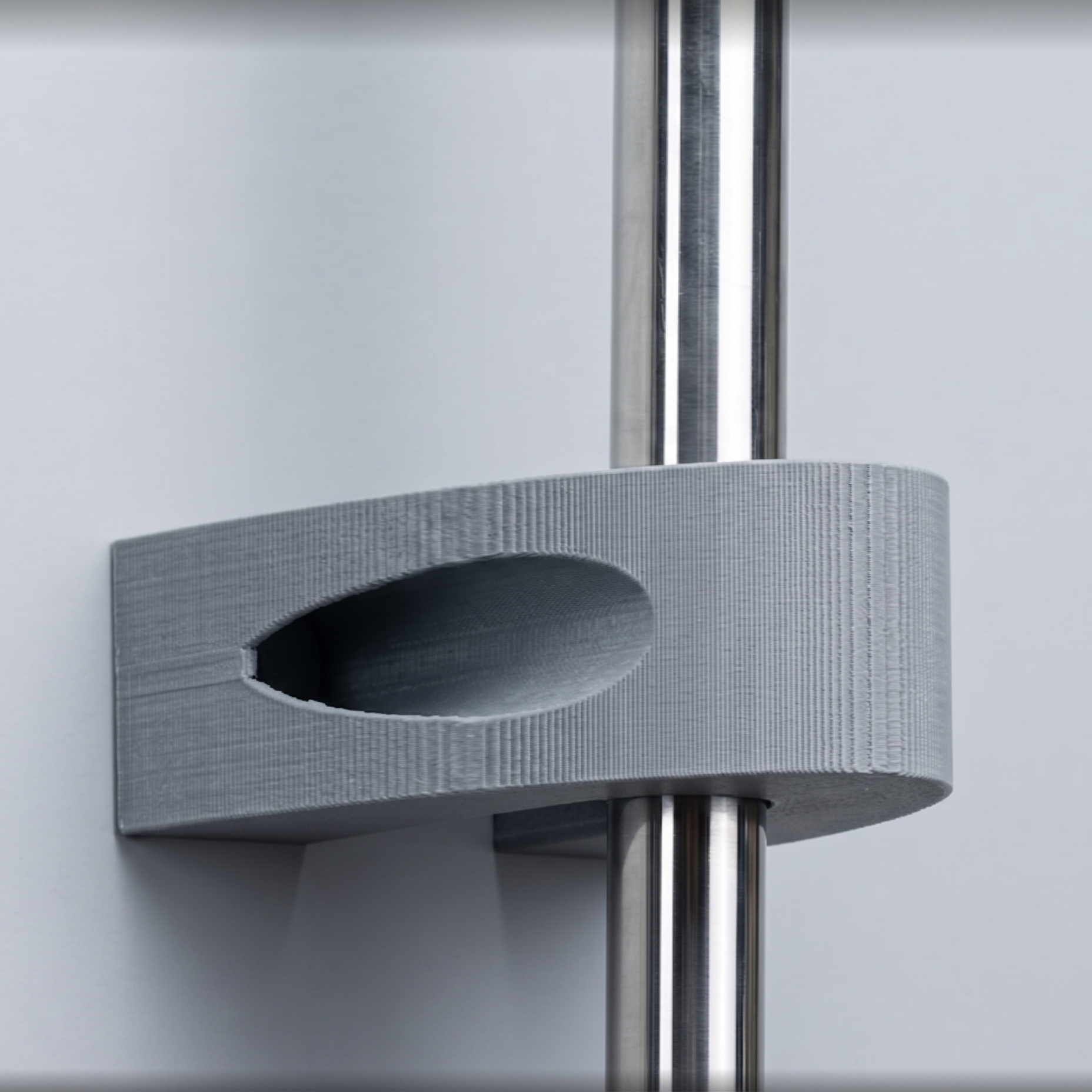 Close view of a real gray 3D-printed bracket shown around a polished support bar in an edited presentation setting